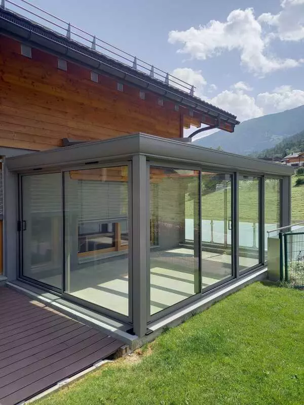 veranda grise adossée à une maison avec bardage bois